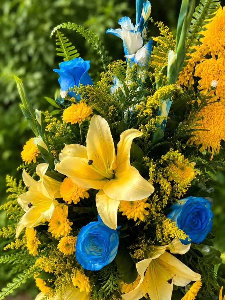 Yellow and blue floral arrangement with fresh greenery